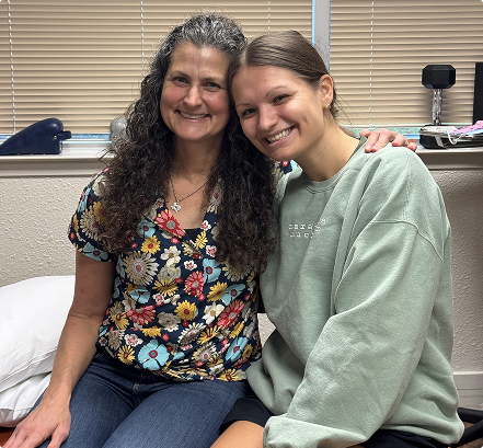 Heidi sitting with her client at a healthcare clinic.
